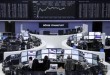 Traders work at their desks in front of the German share price index, DAX board, at the stock exchange in Frankfurt, Germany, March 1, 2016. REUTERS/Staff