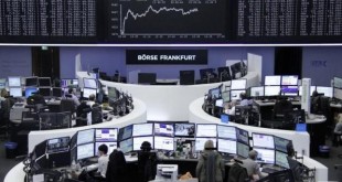 Traders work at their desks in front of the German share price index, DAX board, at the stock exchange in Frankfurt, Germany, March 1, 2016. REUTERS/Staff