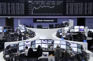 Traders work at their desks in front of the German share price index, DAX board, at the stock exchange in Frankfurt, Germany, March 1, 2016. REUTERS/Staff