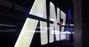 A man is reflected in a logo for the Australia and New Zealand Banking Group Ltd (ANZ) as he walks past a branch located in a Sydney suburb February 17, 2015. ANZ on Tuesday posted a 3.5 percent rise in first-quarter cash profit, warning that 2015 was shaping up to be a "slightly tougher, more volatile" environment. ANZ reported cash profit of A$1.79 billion ($1.39 billion) for the three months to Dec. 31, compared with A$1.73 billion a year ago, led by a strong domestic performance, while lower trading income and higher expenses hurt revenue growth.  REUTERS/David Gray     (AUSTRALIA - Tags: BUSINESS LOGO) - RTR4PV6V