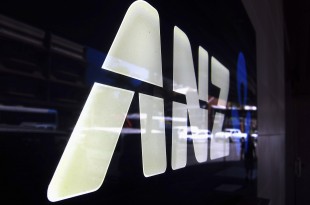 A man is reflected in a logo for the Australia and New Zealand Banking Group Ltd (ANZ) as he walks past a branch located in a Sydney suburb February 17, 2015. ANZ on Tuesday posted a 3.5 percent rise in first-quarter cash profit, warning that 2015 was shaping up to be a "slightly tougher, more volatile" environment. ANZ reported cash profit of A$1.79 billion ($1.39 billion) for the three months to Dec. 31, compared with A$1.73 billion a year ago, led by a strong domestic performance, while lower trading income and higher expenses hurt revenue growth.  REUTERS/David Gray     (AUSTRALIA - Tags: BUSINESS LOGO) - RTR4PV6V