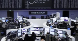 Traders work at their desks in front of the German share price index, DAX board, at the stock exchange in Frankfurt, Germany, March 1, 2016. REUTERS/Staff